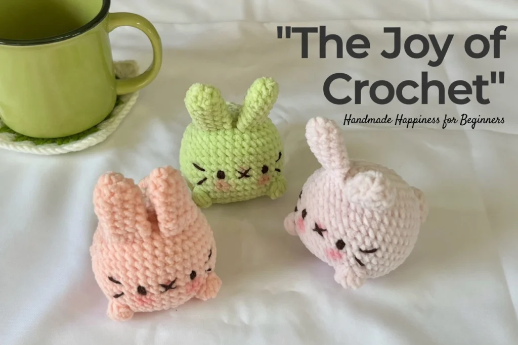 Three handmade amigurumi Mochi Bunnies in peach, lime green, and light pink with embroidered sleepy faces, styled with a green mug and text overlay reading The Joy of Crochet Handmade Happiness for Beginners